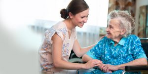 carer and old woman in wheelchair