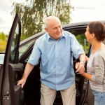 elderly man with carer out driving