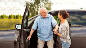 elderly man with carer out driving